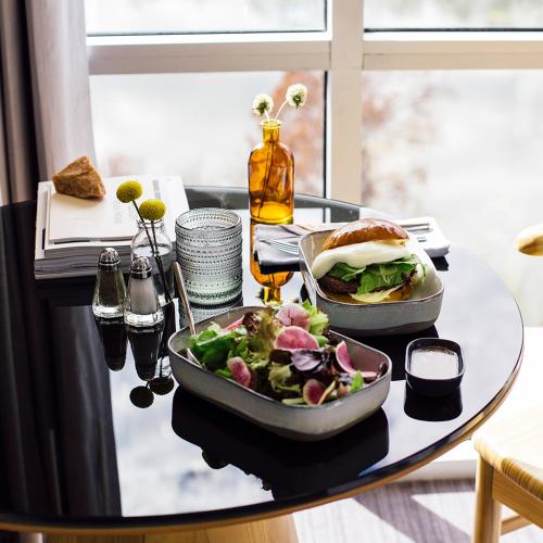 a table with a plate of food and a salad at The LINE Austin in Austin