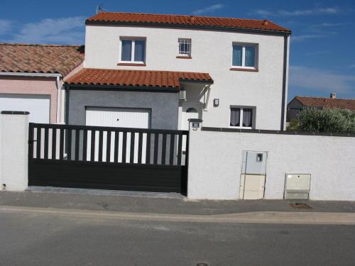 une maison blanche avec un grand garage noir dans l'établissement Douce Parenthèse - Maison de Vacances - 8 pers - Terrasse, à Lapalme