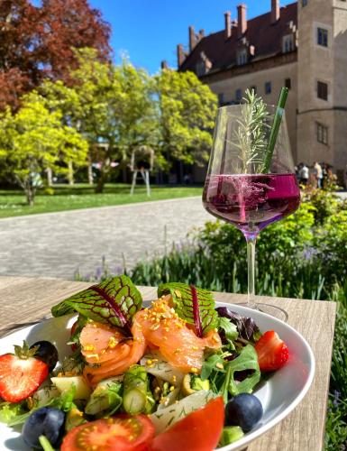 a plate of food and a glass of wine at ALTE SCHULE WITTENBERG, 3 Ferienwohnungen für bis zu 12 Personen, an der Elbe, mit Garten in Lutherstadt Wittenberg
