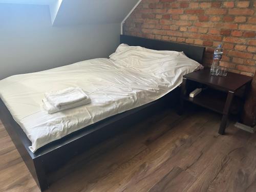 a bed with two towels on it next to a brick wall at Loft&Cozy in Zgorzelec