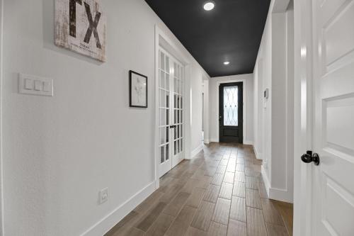a hallway of a home with white walls and wood floors at Lake Cove Retreat in Little Elm