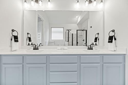 a bathroom with two sinks and a large mirror at Lake Cove Retreat in Little Elm