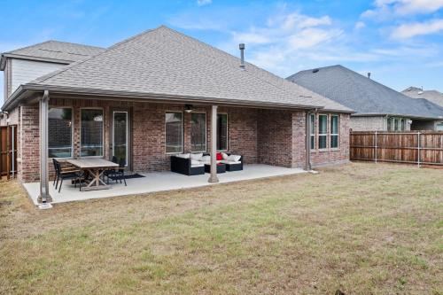 a brick house with a patio with a table at Lake Cove Retreat in Little Elm