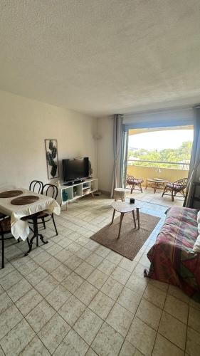 un salon avec un lit et une télévision dans l'établissement Cozy studio for 3 people, à Saint-Raphaël