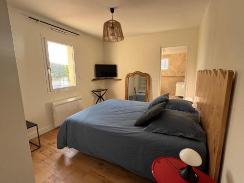 une chambre avec un grand lit et une télévision dans l'établissement La maison de la Corniche, à Plouhinec