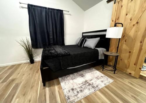 una camera da letto con un letto nero e una finestra di Brand New Bungalow with Amenities a Tulsa