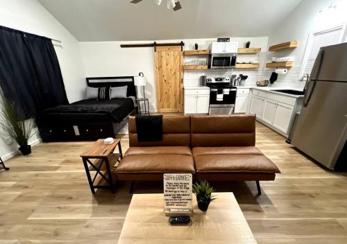 a living room with a couch and a kitchen at Brand New Bungalow with Amenities in Tulsa
