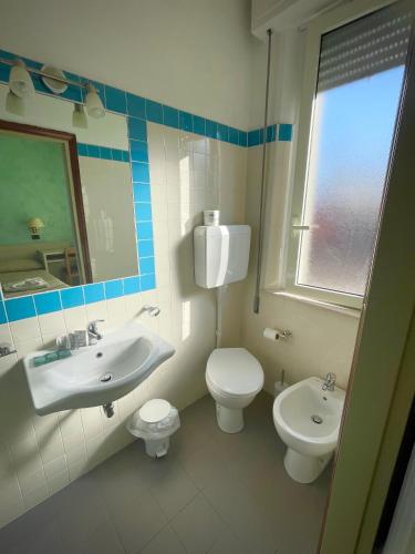 a bathroom with a sink and a toilet and a mirror at Hotel Reale in Rimini