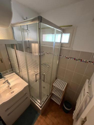 une salle de bain avec une douche en verre et un lavabo dans l'établissement Magnifique studio Vue mer, à Bandol