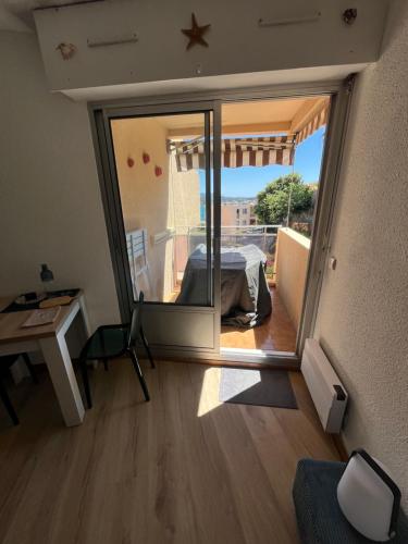 Cette chambre dispose d'un balcon avec un lit et un bureau. dans l'établissement Magnifique studio Vue mer, à Bandol