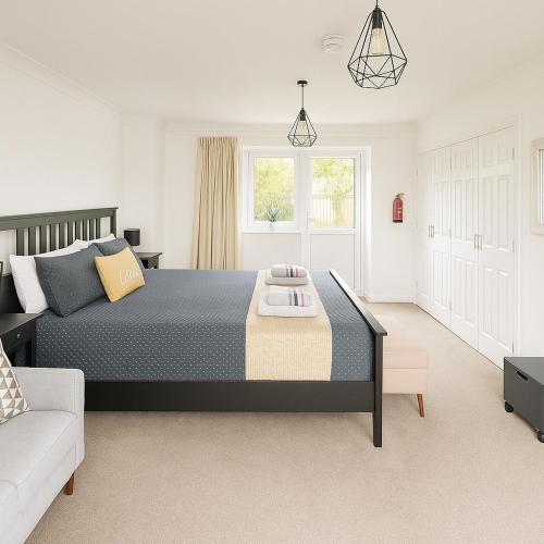 a bedroom with a large bed and a couch at Lytton Tree Lodge Near Southwold in Reydon