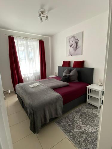 a bedroom with a bed with red sheets and a window at Das Schubert in Gmunden