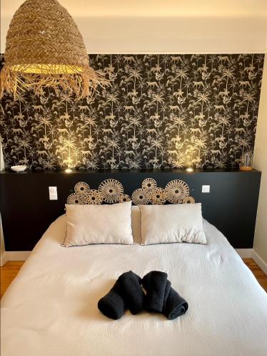 - une chambre avec un lit et 2 serviettes noires dans l'établissement Le Nid Cosy, studio, à Saint-Dié-des-Vosges