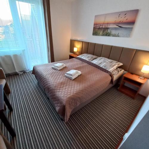 a bedroom with a bed with two towels on it at Akwen in Rewal