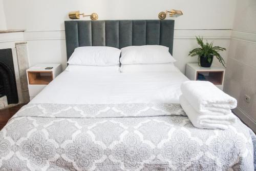 a bedroom with a large white bed with a gray headboard at Inmerso Tango Hotel in Buenos Aires