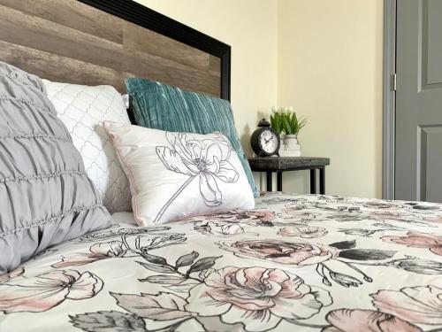a bed with a floral bedspread and pillows on it at Huge 6BR Home , Modern & Convenient in Niagara Falls