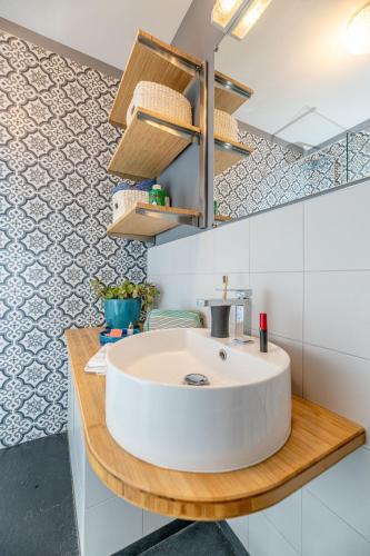 une salle de bain avec un lavabo blanc sur un comptoir en bois dans l'établissement La Casa Azzura, à Nice