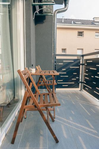 a wooden bench sitting on the side of a balcony at L & S Apartmani in Sombor