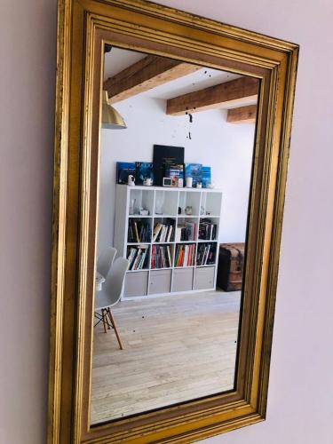 un miroir reflétant une chambre avec une étagère. dans l'établissement Duplex La Ciotat - T2 - Plages & Vieux Port - climatisation, à La Ciotat