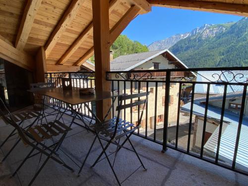 a table and chairs on a balcony with a view at Chalet de charme 190m2, La Lauzière, ski à pieds in Peisey-Nancroix