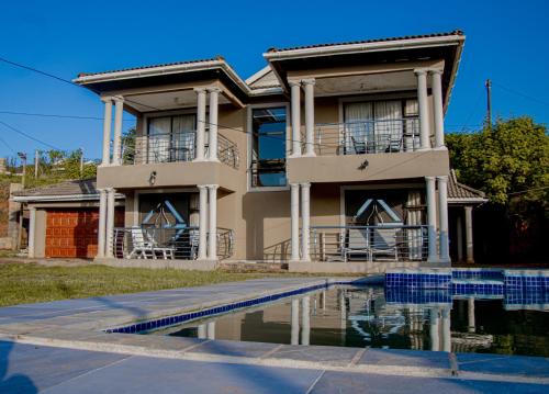 a house with a swimming pool in front of it at PPM BnB in KwaNgongoma