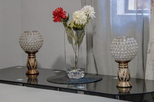 two vases with flowers in them on a table at PPM BnB in KwaNgongoma