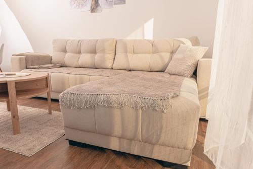 a living room with a couch and a table at L & S Apartmani in Sombor