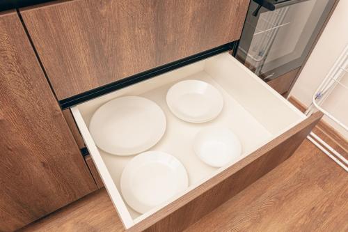 a box with four white dishes in it at L & S Apartmani in Sombor