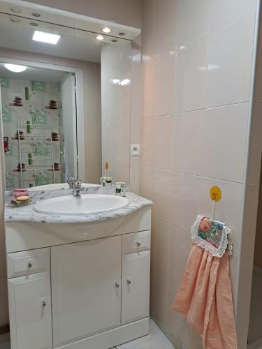une salle de bain blanche avec un lavabo et un miroir dans l'établissement Au doux refuge, à Malemort-sur-Corrèze