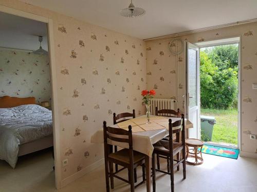 - une salle à manger avec une table, des chaises et un lit dans l'établissement Au doux refuge, à Malemort-sur-Corrèze