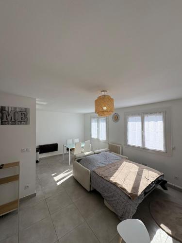 une chambre avec un lit, une table et des chaises dans l'établissement Cozy studio parking privé meyzieu centre, à Meyzieu