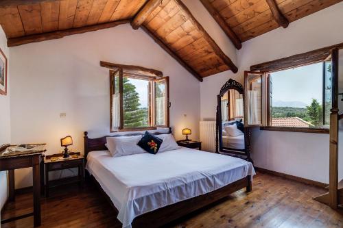 una camera con un grande letto e due finestre di Natalia's Houses a Chania