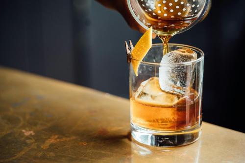 a drink being poured into a glass on a table at Gaarten Hotel Benessere Spa by Kleos Group Collection in Gallio