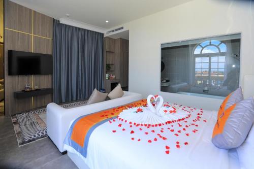 a bedroom with a white bed with red roses on it at Premium CGP Hotel Hoi An in Hoi An