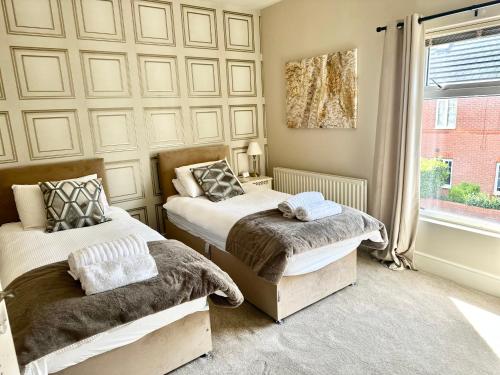 a bedroom with two beds and a window at Moon House Crewe in Crewe