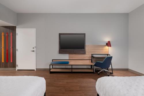 a room with two beds and a desk and a television at Tru By Hilton Houston Downtown Convention Center in Houston