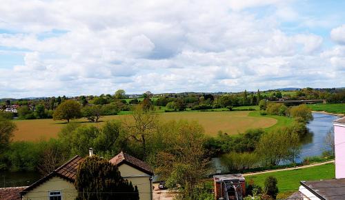 a view of a field and a river with a house at Radcliffe Guest House in Ross on Wye