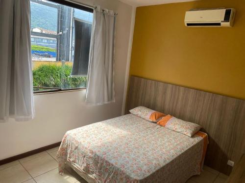 una piccola camera da letto con un letto e una finestra di Casa com deck navegável e jacuzzi em Angra dos Reis RJ - Praia da Ribeira ad Angra dos Reis