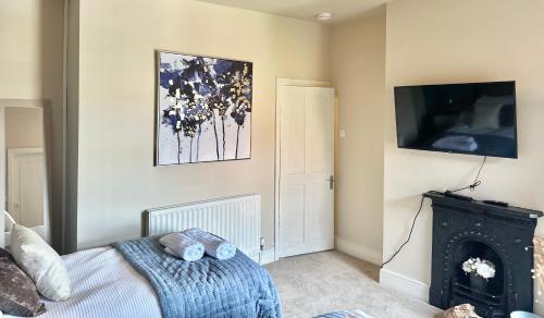 a bedroom with a bed and a television on a wall at Moon House Crewe in Crewe