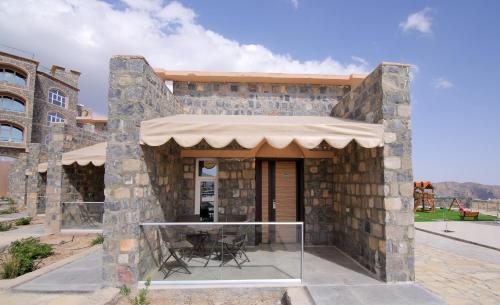 a stone building with a glass entryway at Sama Hotel Jabal Al Akhdar in Al ‘Aqar