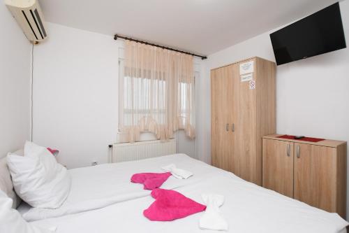 a bedroom with a white bed with red towels on it at Vila Popović Plaža in Kladovo
