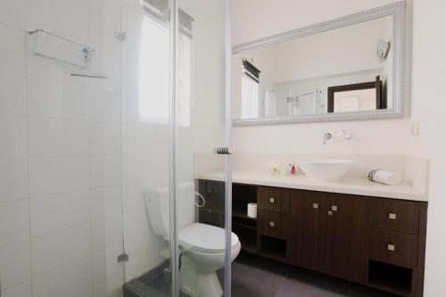 Un baño con inodoro, lavabo y espejo. en Spacious 2BR Apartment with 2 Bathrooms, Living Room & Kitchen - Prime LocationNear ddizengoff st, en Tel Aviv