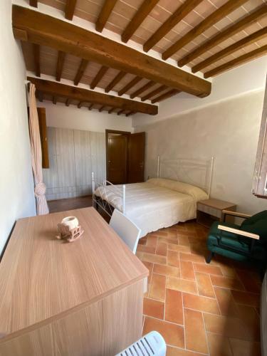 a bedroom with a bed and a table in it at Il rifugio dell'eroe - con piscina in Gaiole in Chianti