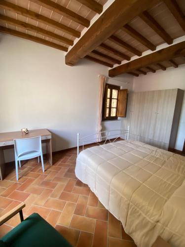 a bedroom with a large bed and a desk at Il rifugio dell'eroe - con piscina in Gaiole in Chianti