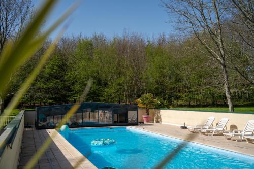 - une piscine dans une maison avec des chaises et des arbres dans l'établissement Gîte Arvor 6P, piscine ou jacuzzi, à Saint-Évarzec