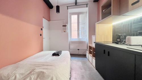 Cette petite chambre comprend un lit et un lavabo. dans l'établissement Le Petit Niçois, à Nice