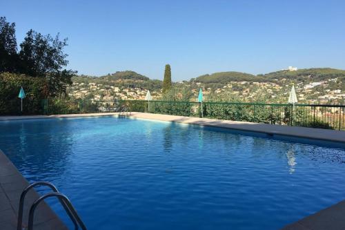 une grande piscine avec vue sur une ville dans l'établissement Quiet flat with private garden, à Vallauris