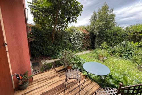 une terrasse en bois avec une table et des chaises dessus dans l'établissement Quiet flat with private garden, à Vallauris
