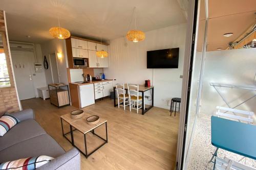 a living room with a couch and a kitchen at Lovely 4-person studio - pool and sea in Saint-Laurent-du-Var
