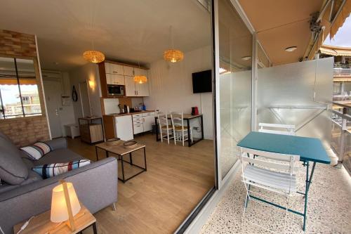 un salon avec un canapé et une table dans l'établissement Lovely 4-person studio - pool and sea, à Saint-Laurent-du-Var